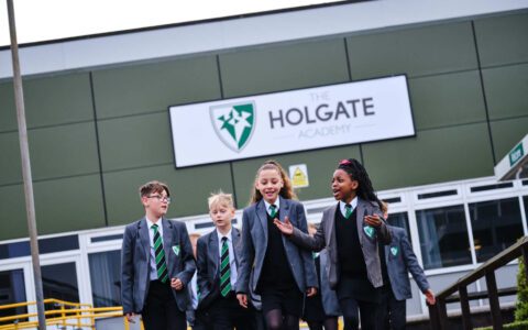 A group of pupils conversing outside of The Holgate Academy building